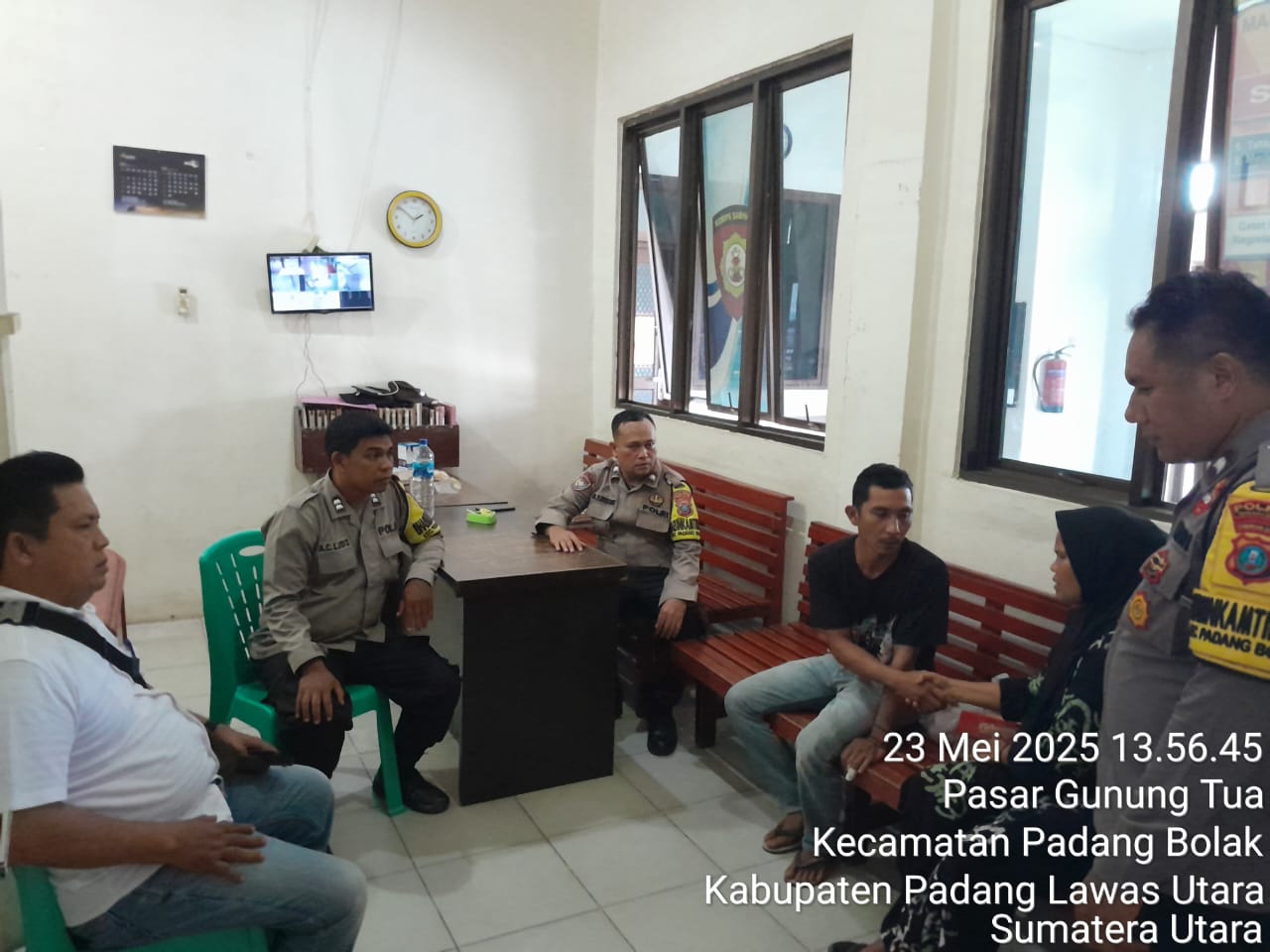 Kedua belah pihak, Siti Aslam Siregar dan suaminya, Anri Ansyah Harahap, bersalaman tanda sudah berdamai disaksikan personel Polsek Padang Bolak