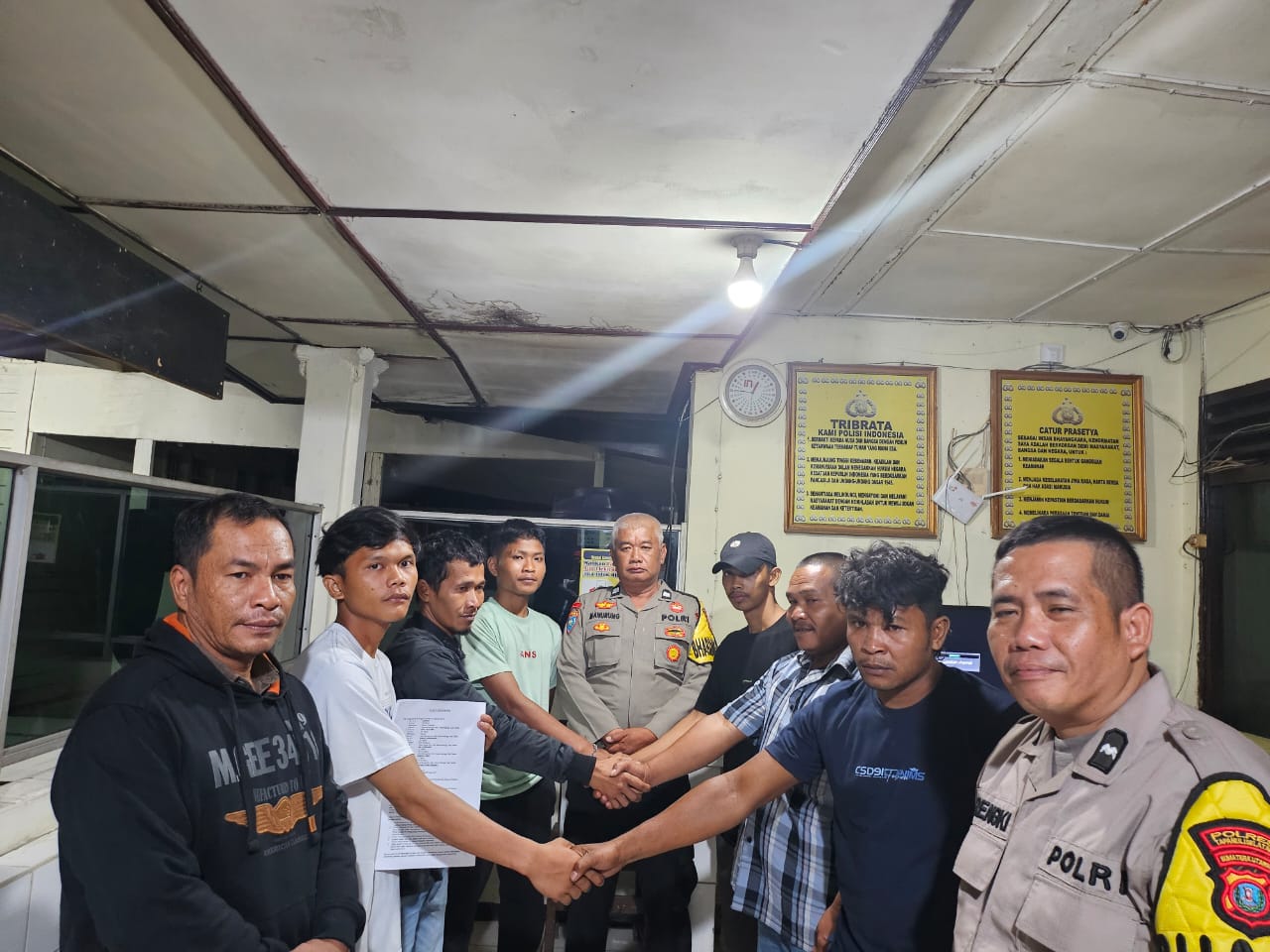 Terlapor dan pelapor bersalaman tanda sudah saling memaafkan atas kasus dugaan pengeroyokan di hadapan personel Polsek Batang Angkola