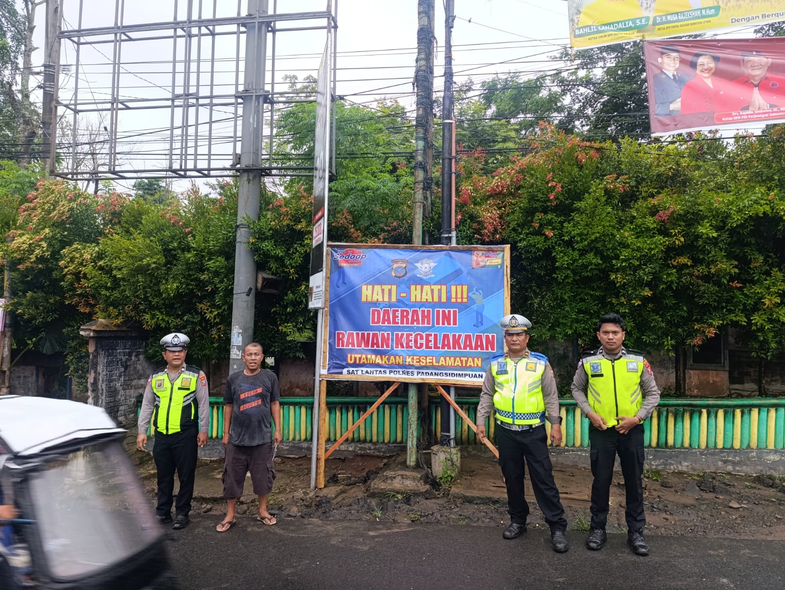 Kanit Turjawali Sat Lantas Polres Padangsidimpuan, Ipda Andi Situmorang, bersama sejumlah anggotanya, usai memasang baliho berisi imbauan terkait keselamatan dan kesadaran tertib berlalu lintas bagi segenap pengguna jalan di titik rawan kecelakaan