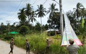 Sejumlah petugas Satpol PP Kota Padangsidimpuan saat menertibkan spanduk liar yang melintang antara tiang listrik