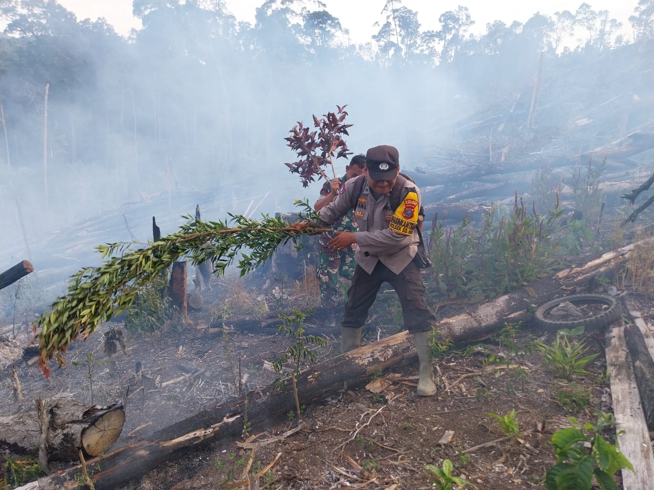 Personel Polsek SD Hole, Polres Tapsel, saat melakukan upaya pemadaman di sebuah lahan yang dibakar oleh pemiliknya untuk mencegah Karhutla