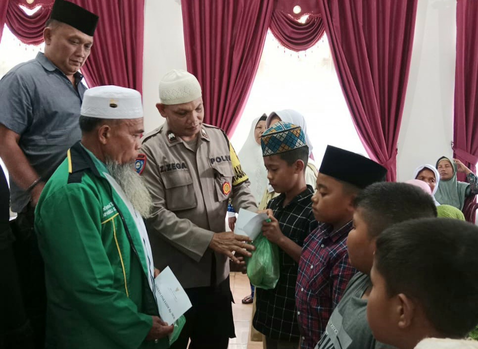 Personel Polsek Batang Toru saat memberi santunan ke anak yatim dalam momen Idul Yatama