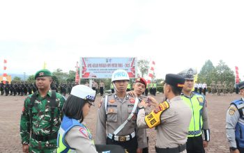 Waka Polres Tapsel, Kompol Rapi Pinakri, saat menyematkan pita tanda Operasi dalam Apel Gelar Pasukan Operasi Patuh Toba 2025