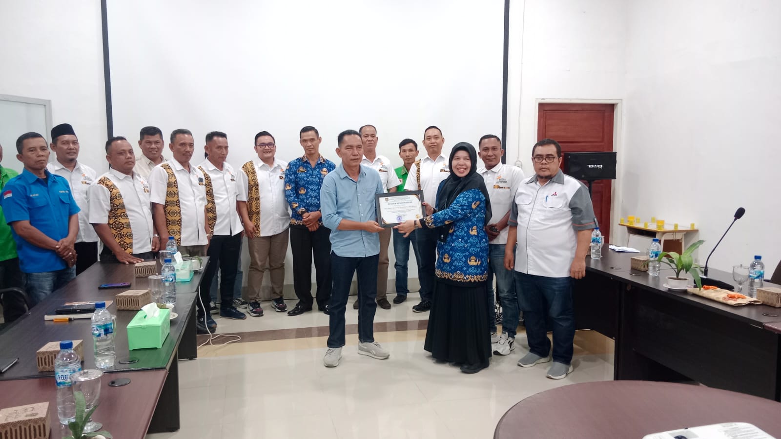 Kadisnaker Kabupaten Asahan, Melina Siregar, menyerahkan penghargaan LKS Bipartit tahun 2025 kepada GM PT BSP Tbk Kisaran