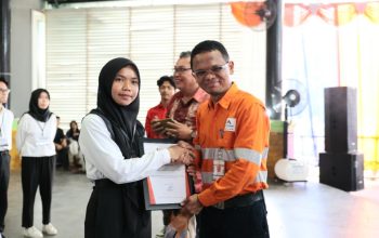 GMO & Deputy Director Operations Agincourt Resources, Rahmat Lubis, menyerahkan sertifikat penghargaan kepada Aisyah Pardede, penerima Beasiswa Martabe Prestasi tingkat sarjana perguruan tinggi negeri di Sopo Daganak, Batang Toru