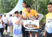 Bupati Tapsel, Gus Irawan Pasaribu, bersama GMO PTAR, Rahmat Lubis, menyerahkan hadiah ke juara pertama lomba lari marathon putera 10 Km secara simbolis dalam agenda Martabe Run 2025
