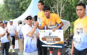 Bupati Tapsel, Gus Irawan Pasaribu, bersama GMO PTAR, Rahmat Lubis, menyerahkan hadiah ke juara pertama lomba lari marathon putera 10 Km secara simbolis dalam agenda Martabe Run 2025