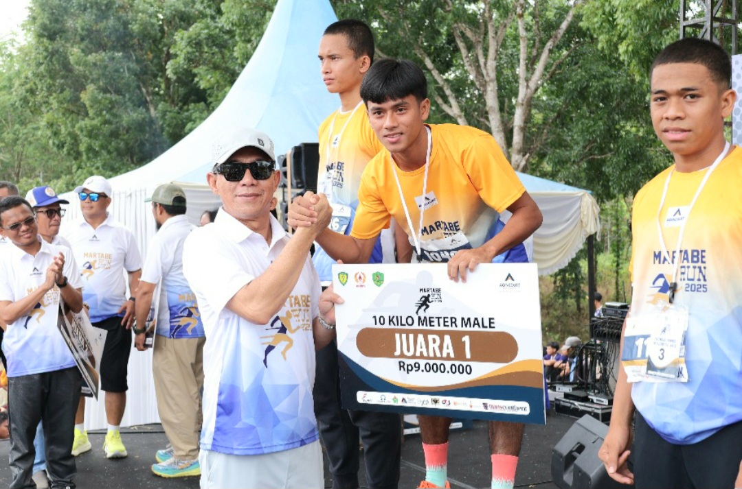 Bupati Tapsel, Gus Irawan Pasaribu, bersama GMO PTAR, Rahmat Lubis, menyerahkan hadiah ke juara pertama lomba lari marathon putera 10 Km secara simbolis dalam agenda Martabe Run 2025