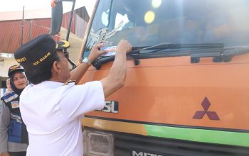 Bupati Tapsel, Gus Irawan Pasaribu, menempelkan stiker terkait imbauan taat pajak ke salah satu kendaraan saat Operasi Terpadu dan Gabungan Opsen PKB dan BBNKB
