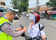 Kasat Lantas Polres Padangsidimpuan, AKP Jonni Silalahi, saat membagikan bendera merah putih sekaligus memasangkannya ke salah satu sepeda motor pengguna jalan yang melintas Dalam rangka menyemarakkan HUT Kemerdekaan RI ke-80