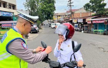 Kasat Lantas Polres Padangsidimpuan, AKP Jonni Silalahi, saat membagikan bendera merah putih sekaligus memasangkannya ke salah satu sepeda motor pengguna jalan yang melintas Dalam rangka menyemarakkan HUT Kemerdekaan RI ke-80