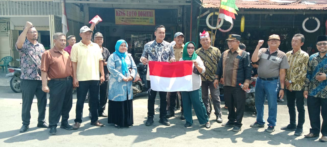 Camat Kota Kisaran Barat, Rahmad Aris Munandar, turun langsung ke jalan membagikan 500 bendera merah putih ke masyarakat