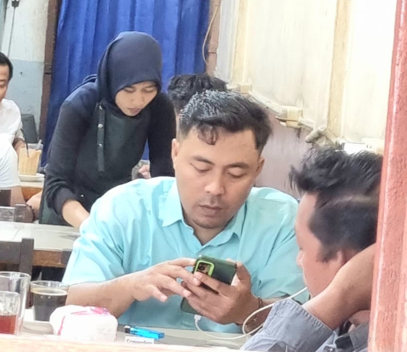 Ketua SMSI Padangsidimpuan, Khairul Arief Nasution, duduk nyantai sembari ngopi di Kafe Hijrah bersama sejumlah wartawan guna mendiskusikan jurnalisme solutif di tengah aroma robusta lokal yang menyeruak
