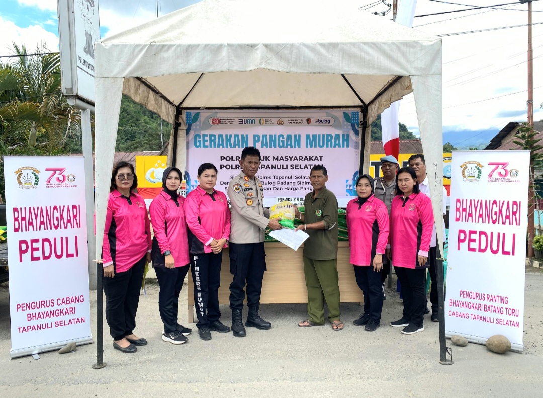 Kapolsek Batang Toru, AKP PM Siboro, didampingi para Pengurus Bhayangkari, saat menyerahkan sekarung beras murah bagi warga yang membutuhkan di sela program GPM di wilayah hukumnya