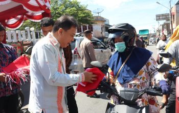 Wakil Bupati Tapsel, Jafar Syahbuddin Ritonga, membagikan bendera merah putih dalam rangka menyemarakkan HUT Kemerdekaan RI ke-80 tahun 2025