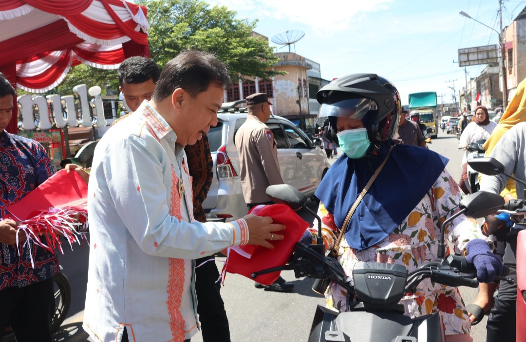 Wakil Bupati Tapsel, Jafar Syahbuddin Ritonga, membagikan bendera merah putih dalam rangka menyemarakkan HUT Kemerdekaan RI ke-80 tahun 2025