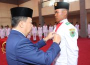 Wabup Tapsel, Jafar Syahbuddin Ritonga, mengukuhkan salah seorang perwakilan Paskibra