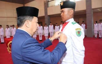 Wabup Tapsel, Jafar Syahbuddin Ritonga, mengukuhkan salah seorang perwakilan Paskibra