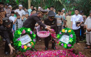 Kapolsek Batang Toru, AKP Penggar Marinus Siboro, saat menaburkan bunga di tempat persemayaman terakhir personel Bhabinkamtibmasnya, Ipda Ahmad Zubir Ritonga