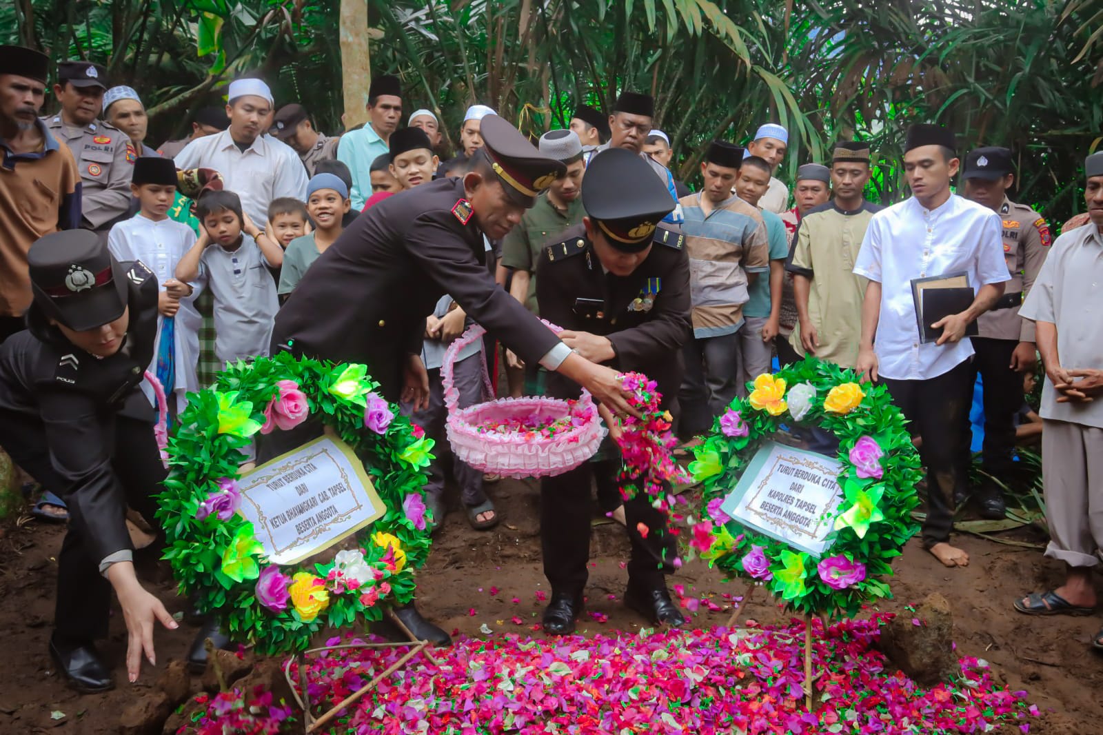 Kapolsek Batang Toru, AKP Penggar Marinus Siboro, saat menaburkan bunga di tempat persemayaman terakhir personel Bhabinkamtibmasnya, Ipda Ahmad Zubir Ritonga