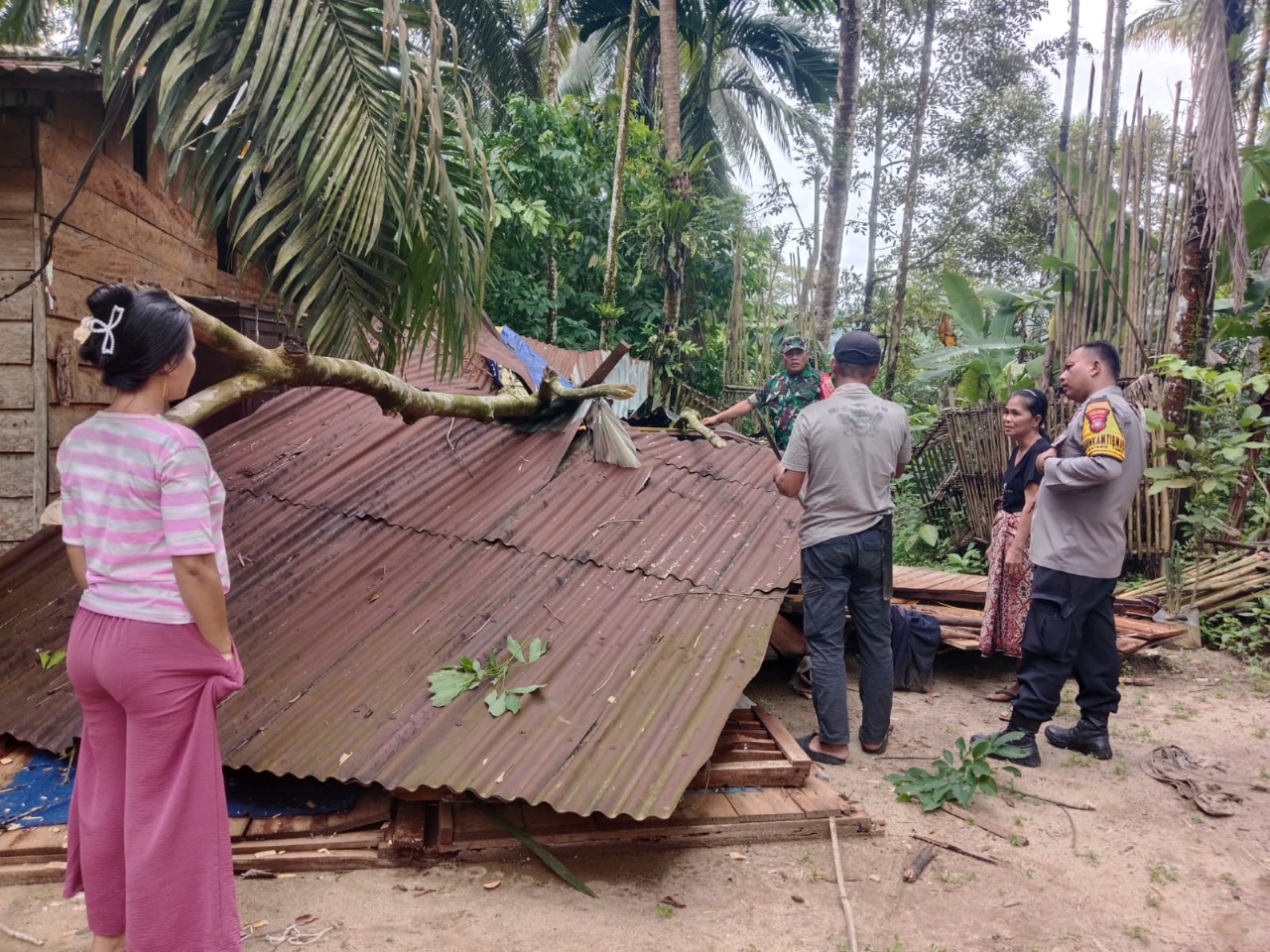 Bhabinkamtibmas Polsek Batang Toru, Bripka Adi Suito, bersama Babinsa Koramil 01/BT, Serka K Siregar, saat turun langsung ke rumah salah satu warga yang tertimpa pohon.