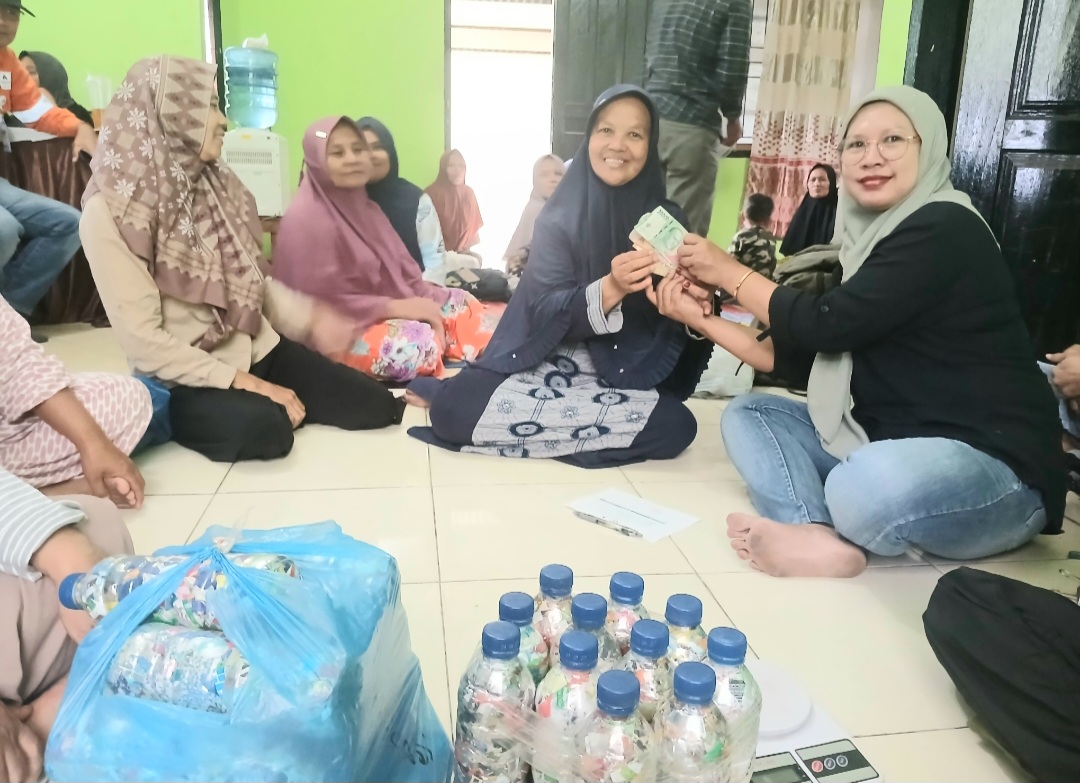 Rusliana, ibu rumah tangga yang sehari-hari berjualan jajanan anak-anak di sekitar lingkar tambang emas Martabe, terlihat sumringah usai menerima uang hasil penjualan 6 botol Ecobrick yang dibuatnya, lewat program kerja sama antara PTAR dan Bank Sampah Yamantab