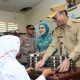 Bupati Tapsel, Gus Irawan Pasaribu, bersama Ketua TP PKK Ny Murni Gus Irawan, menyajikan langsung sajian makanan bergizi ke salah satu siswa di sela peninjauan pelaksanaan perdana program MBG di SD Negeri 101216 Situmba