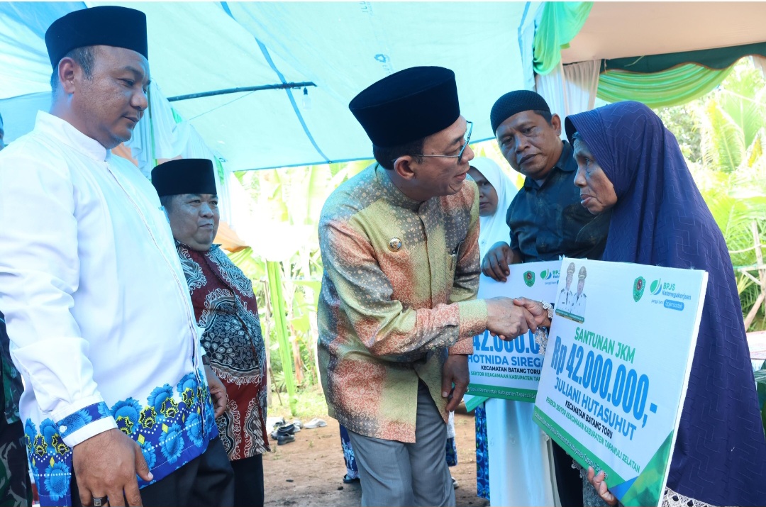 Bupati Tapsel, Gus Irawan Pasaribu, menyapa Juliani Hutasuhut, salah satu warga penerima manfaat santunan JKM BPJS Ketenagakerjaan senilai Rp42 juta saat Safari Maulid Nabi Muhammad SAW 1447 H yang dirangkai dengan pengajian Pemerintah Kecamatan dan BKMT Batang Toru
