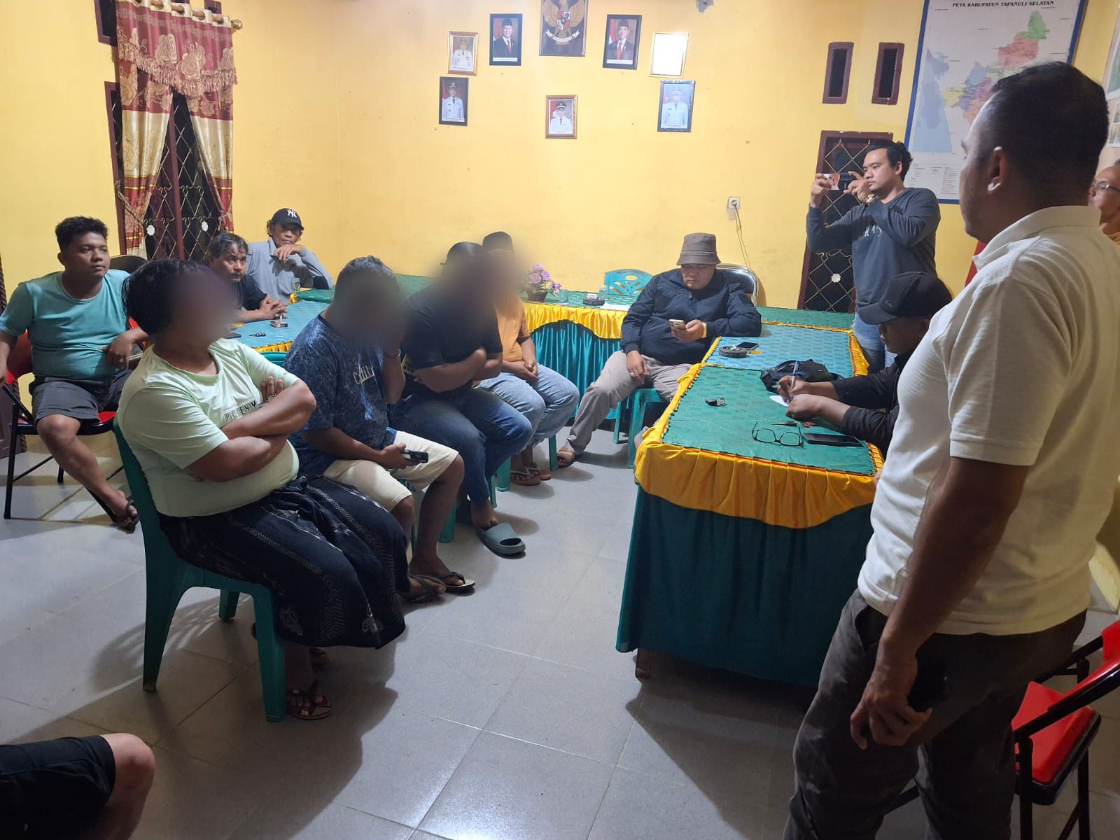 Keenam orang pria yang kini menjadi terlapor atas dugaan pembuatan konten tak senonoh saat dimintai keterangannya oleh Sat Intelkam Polres Tapsel disaksikan masyarakat di Kantor Desa Aek Badak Jae