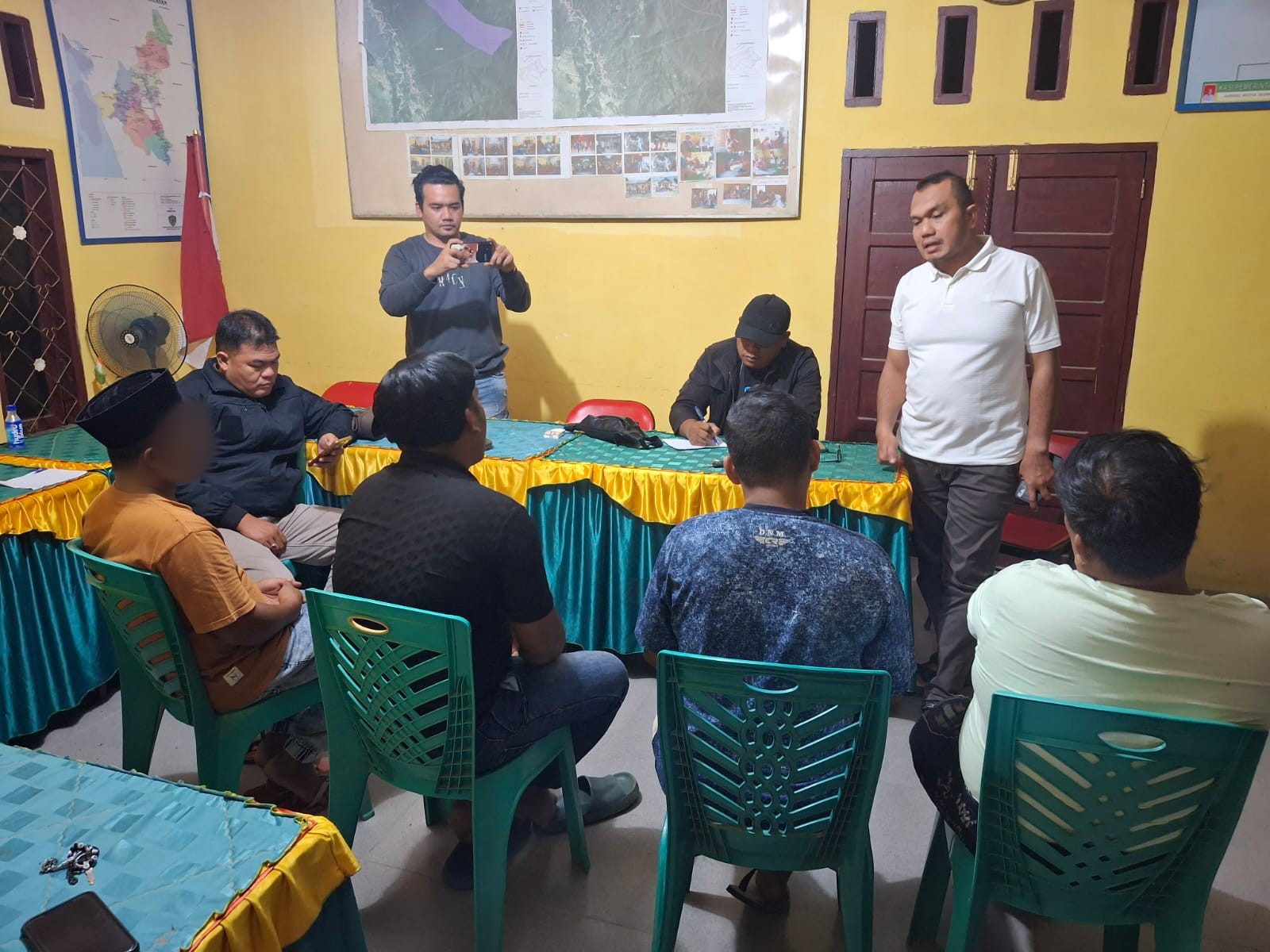 Kasat Intelkam Polres Tapsel, AKP Oloan Lubis, dan anggota, disaksikan perangkat desa serta masyarakat, saat memintai keterangan para terduga pembuat video konten yang dinilai tak pantas di Kantor Desa Aek Badak Jae