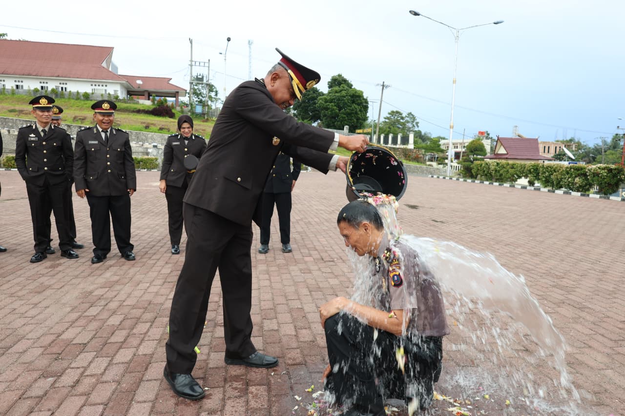 Kapolres Tapsel, AKBP Yon Edi Winara, saat menyirami air bunga ke Kompol Rianto Polman Pasaribu, selaku Plt Kasiwas yang naik pangkat dari AKP terhitung mulai 1 Oktober 2025 (TMT 01-10-2025), sebagai tradisi ungkapan rasa syukur atas dedikasi dan kinerja selama bertugas