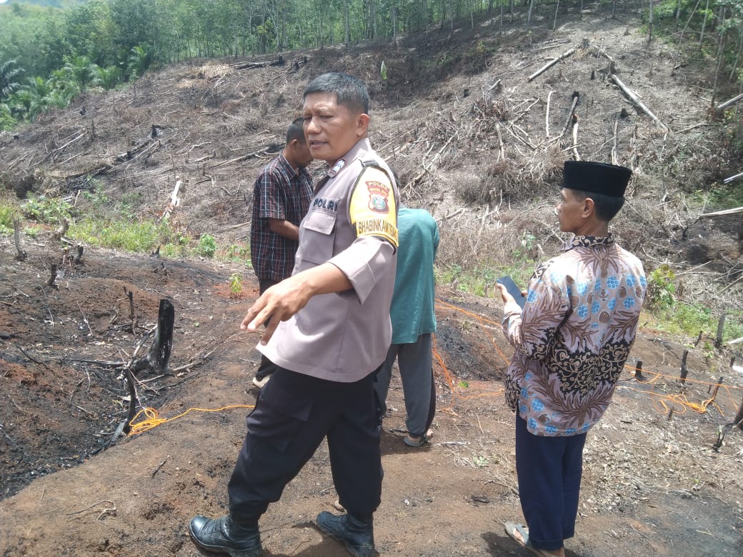 Bhabinkamtibmas Polsek Padang Bolak, Aipda Hilman S Harahap, mendampingi pengecekan batas tanah kebun saat proses mediasi antar-warga yang sempat berselisih