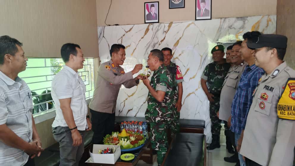 Kapolsek Batang Toru, AKP Penggar M Siboro, didampingi Kanit Reskrim, Ipda Hary Agus Pohan, dan jajaran, menyulangi nasi tumpeng ke Danramil 01/BT, Lettu Inf Saukani Nasution, sebagai ungkapan syukur dalam momen memperingati HUT TNI ke-80