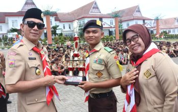 Bupati Tapsel, Gus Irawan Pasaribu, saat menyerahkan trofi ke perwakilan SMK N 1 Batang Angkola yang keluar sebagai juara ketiga lomba vidio pendek dalam agend Perkemahan Bersama 'Tapsel Bangkit' 2025