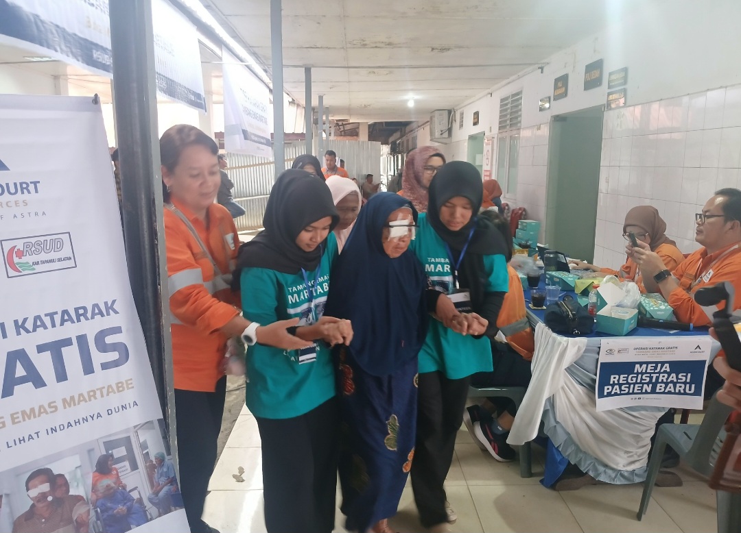 Salah seorang pasien terlihat dipapah oleh sejumlah relawan usai menjalani operasi katarak gratis yang digelar tambang emas Martabe