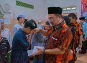 Ketua MPC Pemuda Pancasila Tapsel, Rocky AP Gultom, saat menyerahkan santunan ke perwakilan anak yatim Yayasan Maimun Basilam Baru di sela pelaksanaan Bakti Sosial dalam rangka memperingati HUT Pemuda Pancasila ke-66 dan Hari Jadi Tapsel ke-75