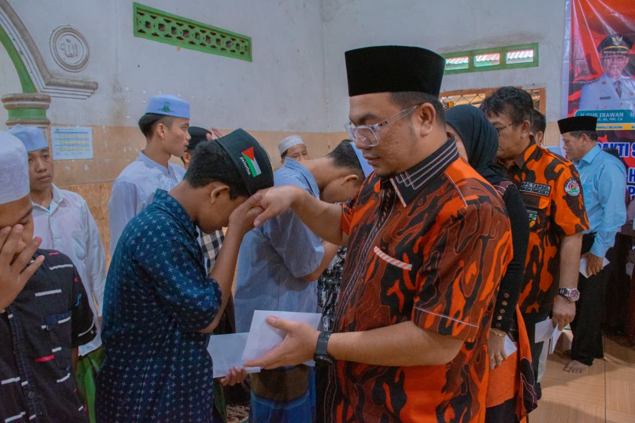 Ketua MPC Pemuda Pancasila Tapsel, Rocky AP Gultom, saat menyerahkan santunan ke perwakilan anak yatim Yayasan Maimun Basilam Baru di sela pelaksanaan Bakti Sosial dalam rangka memperingati HUT Pemuda Pancasila ke-66 dan Hari Jadi Tapsel ke-75